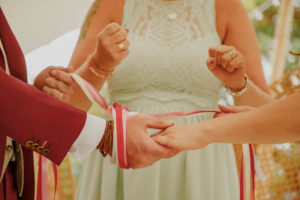 Cérémonie laïque de mariage à Veyrier-du-Lac, au Domaine de la Croix des Champs. Le rituel des mains liées ou handfasting. Mariage en Haute-Savoie Cérémonie symbolique
